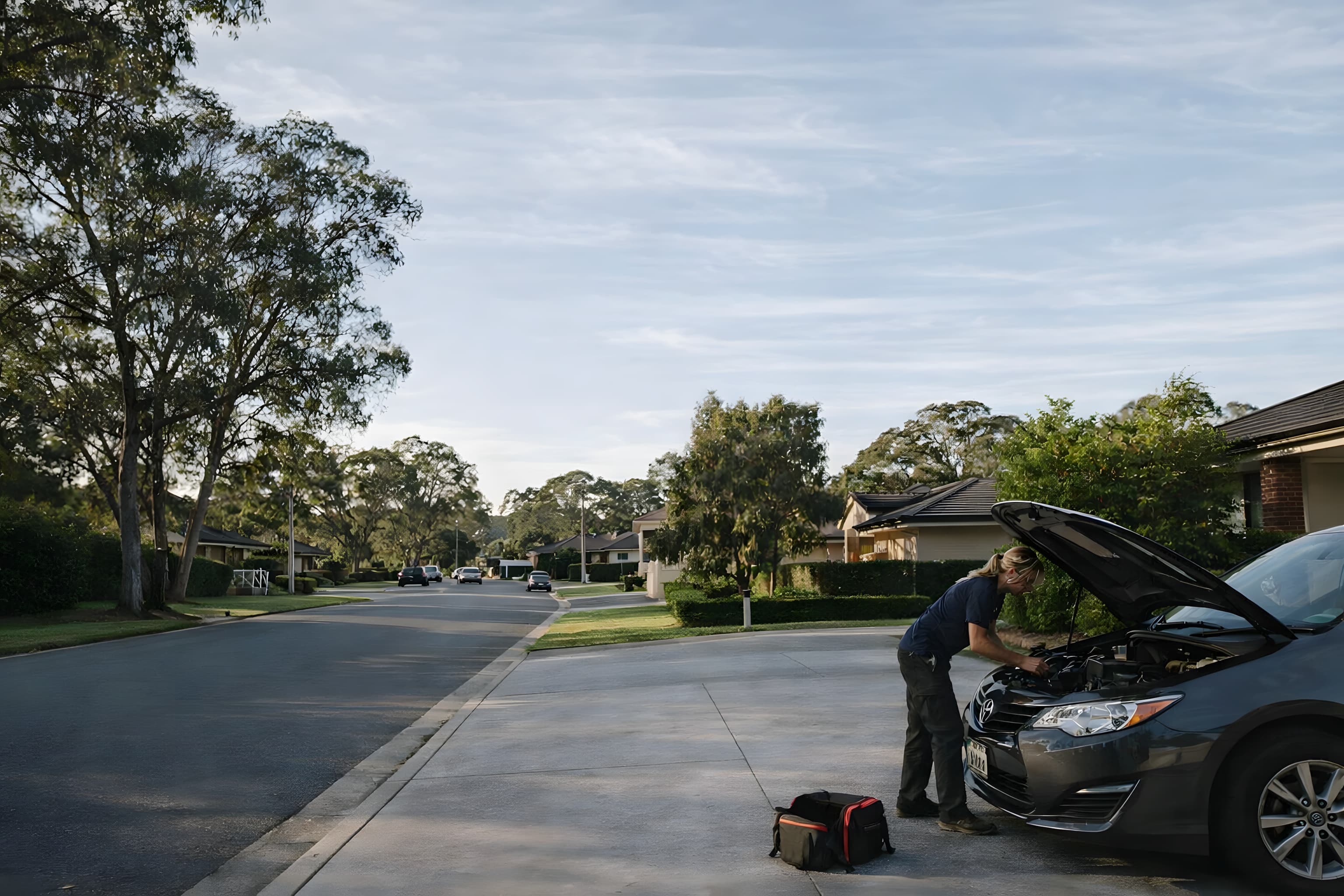 Amy working underneath a vehicle in a driveway